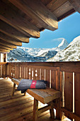 Blanket on bench on chalet balcony with panoramic view of mountains
