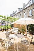 Sunny seating area in courtyard behind old terrace houses
