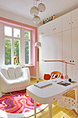 White designer armchair, cupboards and desk in study