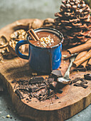Rich winter hot chocolate with cinnamon sticks and walnuts