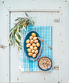 Green big olives in blue ceramic plate with spices