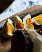 Hard-boiled eggs in wedges on a wooden board