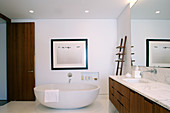 Frei stehende Badewanne und Waschtisch mit Marmorplatte in elegantem Badezimmer