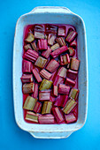 Roasted rhubarb with sugar and ginger in a baking dish (seen from above)