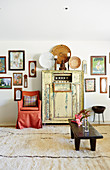 Japanese-style living room, chest of drawers with lanterns, chair with red cover and wooden bench, picture collection on the wall