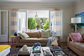 Beige sofa set and coffee table in front of open patio door