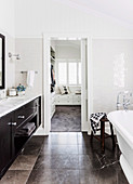 Bathroom with marble tiled floor, view into dressing room through open sliding door