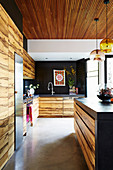 Offene Küche mit Holzfronten und Betonboden
