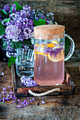Refreshing lilac lemonade with lilac syrup, lemons and ice cubes