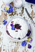 A festive pavlova with berries and pansies
