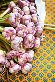 Fresh garlic on a bright yellow tablecloth with a blue pattern
