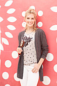 A blonde woman wearing a top and a cardigan with an ice cream