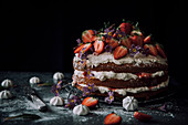 Three layered tower cake with strawberries, fresh cream and edible flowers (primroses)