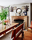 Wooden table and bench in front of open fireplace in dining room
