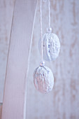 White-painted walnuts decorated with pearls and hung up as Christmas decorations