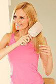 A blonde woman brushing her long hair