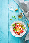 Simple summer caprese salad with mozzarella cheese, colouful tomatoes and fresh basil