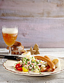 Wurstteller mit Wiener Würstchen, Kartoffelsalat mit Gemüsewürfel, Erbsen und Mayonnaise und ein hartgekochtes Ei