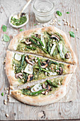 Vegan pizza with pesto, asparagus, courgette, mushrooms and pine nuts