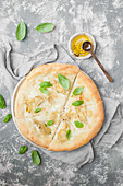 Pizza bianca with artichokes and mozzarella di bufala, served with freh basil and olive oil