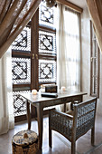 Desk in front of window with Oriental shutters