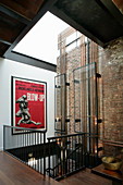 Glasverkleidung an Kupferrohren im Treppenhaus mit Filmplakat