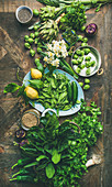 Green vegetables, fruit, seeds, sprouts, flowers, greens over wooden background