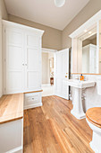 Klassisches Badezimmer in Weiß mit Holzboden