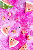 Watermelon slices on a white plate on a pink surface