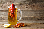 Beer party. Still life with glass of beer, crayfish crawfish against old wooden rustic background