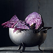 Red cabbage pieces with drops of water in an old metal colander