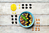 Chocolate smoothies breakfast bowl with chocolate chips, mango, blackberry, almond and Chia seeds