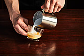 A man preparing a caffe latte