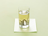 Weißer Tee in Glas mit Teefilter aus Metall