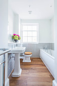 Vintage-style sink against wall tiled to half height with ledge