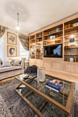 Illuminated fitted cabinets in classic living room in earthy shades