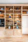 Wooden fitted cabinets with indirect lighting and glass shelves