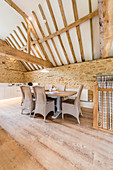 Dining area below exposed roof structure in converted barn