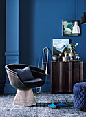 Klassiker Lounge Sessel, Trompete neben Siedeboard vor blauer Wand im Wohnzimer