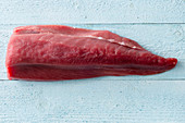 Thunfischfilet auf pastellblauem Holzuntergrund