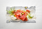 Food-Art: Thunfisch mit roten Zwiebeln, Zucchini, Dill, Olivenöl und Krabbenchips auf Aquarell