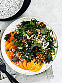 Healthy persimmon and farro salad with kale, watercress, goat cheese and nuts
