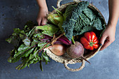 Wicker basket of autumn vegetables with hands