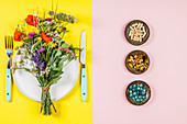 Flat lay of wild flower bouquet on white plate and herbal capsules