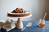 Käsekuchen mit gerösteten Feigen und Nüssen auf Kuchenständer