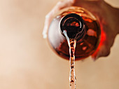 Detail image of rose wine being poured out of the bottle