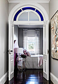 View through the open door into the bedroom with black floorboards