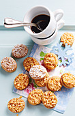 Small crunchy cookies filled with elderberry jam, served with a cup of coffee