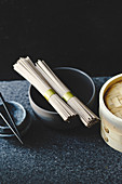 Soba-Nudeln, Bambusdämpfer, Schälchen und Ess-Stäbchen (Asien)