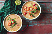 Traditional thai soup tom yum with shrimps and mushrooms, served with fresh lime slices